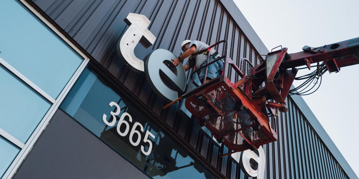The Tekna sign being put on a building